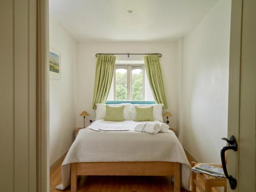 een slaapkamer met een groot bed en een raam bij Garden House in Totnes