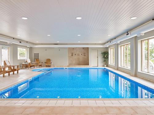 a large swimming pool in a home with a large ceiling at Garden House in Totnes