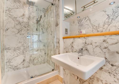 een witte badkamer met een wastafel en een douche bij 5 The Pottery in Dartmouth