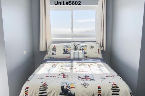 a bedroom with a bed with a comforter and a window at Gulf Shores Plantation Condos in Gulf Shores