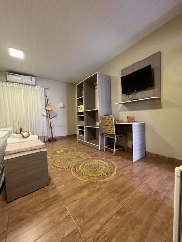 サンタレンにあるPousada do Lago Boutiqueのベッド、デスク、テレビが備わる客室です。