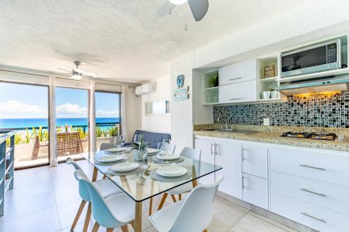 Cancun Ocean view في كانكون: مطبخ وغرفة طعام مع طاولة وكراسي