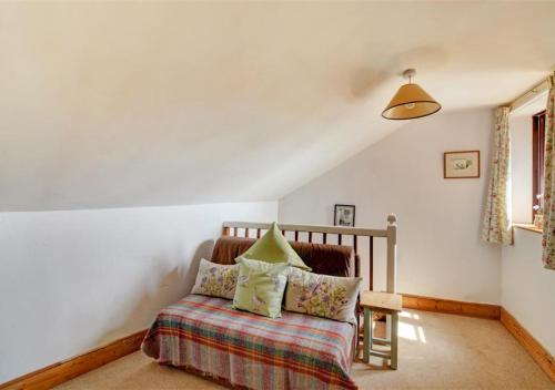 a bedroom with a bed and a chair in a room at Poppy Cottage in Bodham