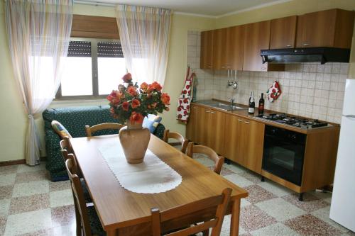 una cucina con tavolo e vaso di fiori di Salento Al Mare a Taviano