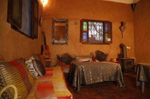 a living room with a couch and a guitar at DAR OUZOUD Vegan in Ouzoud