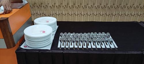 a table with a bunch of forks and plates at DIDI Hotel Alambagh in Alambagh