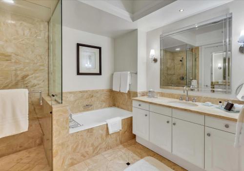 a bathroom with a tub and a sink and a mirror at Amazing studio in Four Seasons Residences Brickell! in Miami