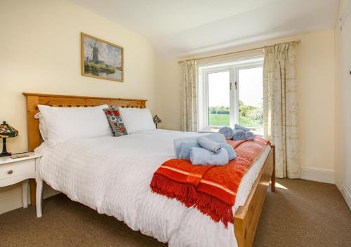 a bedroom with a bed with two stuffed animals on it at The Cottage in Hickling