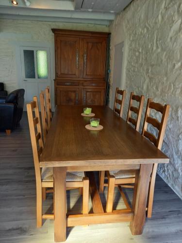 - une table à manger avec des chaises et une table en bois dans l'établissement La petite halte, à Bellac