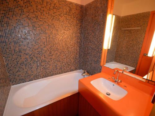 uma casa de banho com uma banheira branca e um lavatório. em Studio Les Menuires, 1 pièce, 2 personnes - FR-1-452-221 em Les Menuires