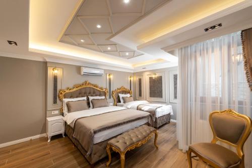 two beds in a bedroom with a coffered ceiling at Azalea Mansion Oldcity in Istanbul