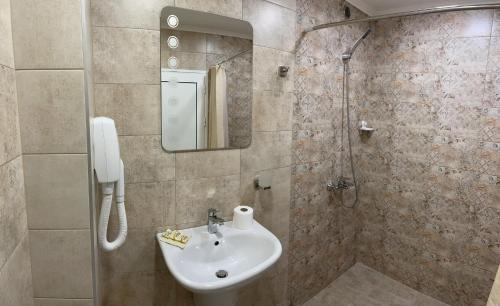 a bathroom with a sink and a shower at Guesthouse Hitar Petar in Gabrovo