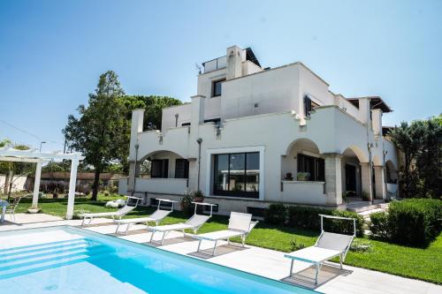 Villa con piscina frente a una casa en Villa Vespucci en Torricella