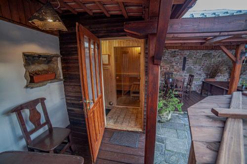eine offene Tür zu einer Terrasse mit einem Tisch und Stühlen in der Unterkunft Apartamenty przy górskich rzekach in Nowy Targ