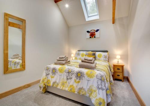 a bedroom with a bed and a mirror at Green Farm Barns - The Old Dairy in Brundall