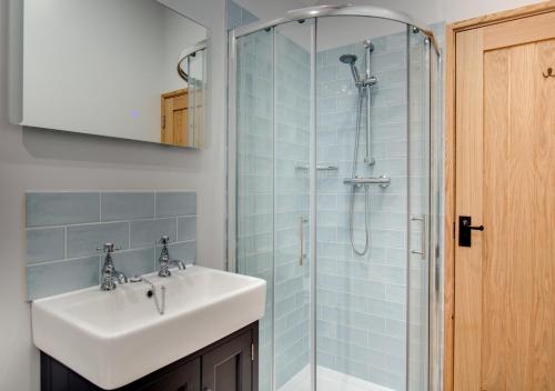 a bathroom with a sink and a shower at Green Farm Barns - The Old Dairy in Brundall