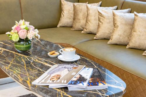 a coffee table with a book and a cup of coffee at Golden Sands Hotel Apartments in Dubai