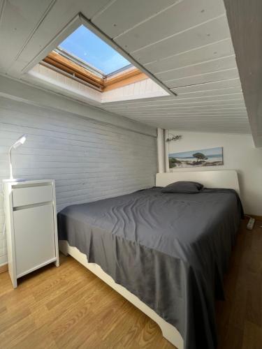 - une chambre avec un grand lit et une lucarne dans l'établissement La maisonnette de Gruissan, à Gruissan