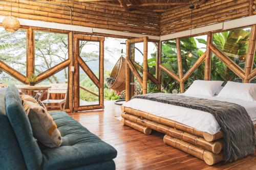 een slaapkamer met een bed, een bank en ramen bij The Coffee Club Campestre in Chinchiná