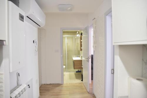 a bathroom with white walls and a hallway with a sink at Stan Na Dan Central Park in Raška