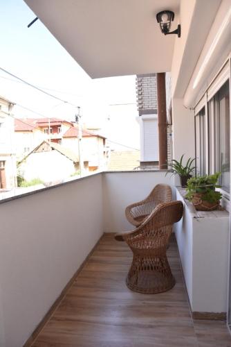 a balcony with a rattan chair and plants at Stan Na Dan Central Park in Raška