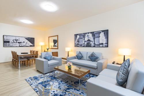 salon z 2 kanapami i stołem w obiekcie Golden Sands Hotel Apartments w Dubaju