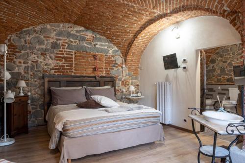 ein Schlafzimmer mit einem großen Bett in einer Ziegelwand in der Unterkunft B&b Il Cortile in Biella