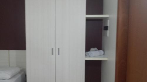 a white cabinet with a mirror and a bed at Flat Le Jardin Suites in Caldas Novas