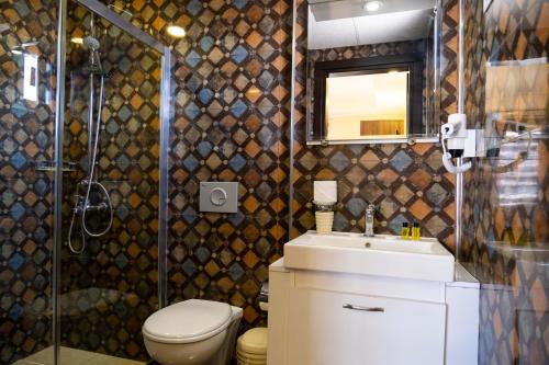 a bathroom with a toilet and a sink and a shower at ikarushotel in Aydın
