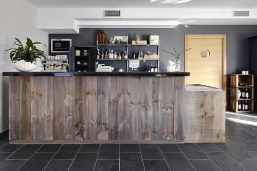 a bar in a room with a wooden wall at Hotel San Prudentzio in Getaria