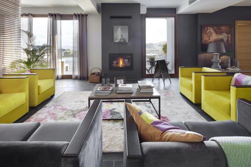 a living room with couches and a fireplace at Hotel San Prudentzio in Getaria