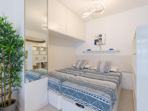 Dormitorio pequeño con cama y espejo en Casa Blanca Las Canteras, en Las Palmas de Gran Canaria