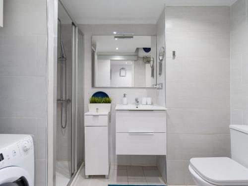 Baño blanco con lavabo y aseo en Casa Blanca Las Canteras, en Las Palmas de Gran Canaria