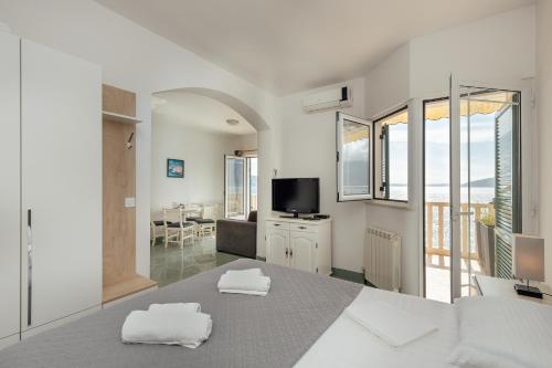 a bedroom with a bed with two towels at Palma Apartments in Herceg-Novi