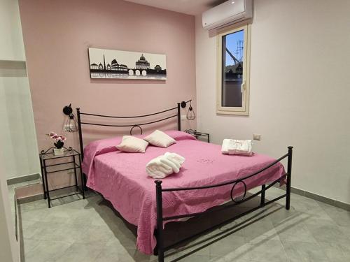 a bedroom with a pink bed with two pillows on it at Saint Peter Vatican City confortable Apartament Stellasia casa vacanza in Rome