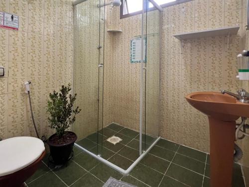 y baño con ducha, aseo y lavamanos. en Tombo Beach Hostel & Pousada, en Guarujá