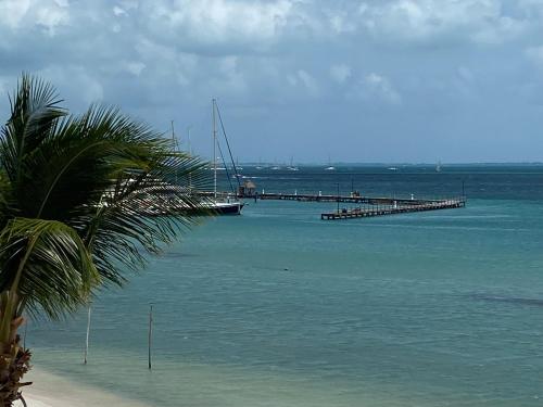 a pier with a boat in the water next to a beach at Tropical apartment in Cancún