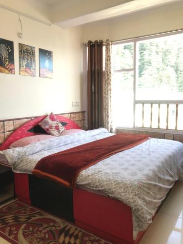 a bedroom with a large bed with a window at Shimla Regency in Shimla