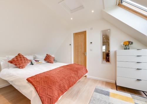 a white bedroom with a bed and a dresser at Beech Corner in Cawston