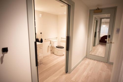 a bathroom with a toilet and a large mirror at Virgin Hotels New Orleans in New Orleans