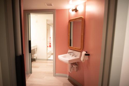 a bathroom with a sink and a mirror on the wall at Virgin Hotels New Orleans in New Orleans
