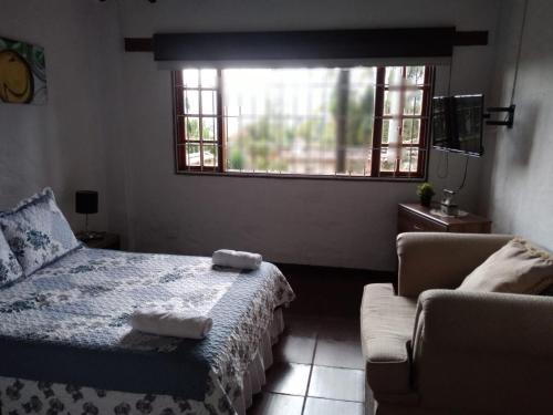 a bedroom with a bed and a couch and a window at Hotel Campestre Franchesca in Tabio