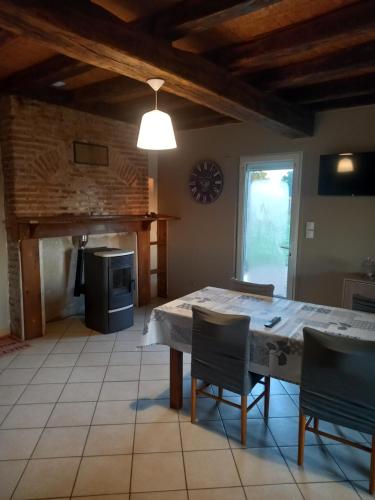 une cuisine avec une table et des chaises dans une pièce dans l'établissement Chez Mimi, à Trévol
