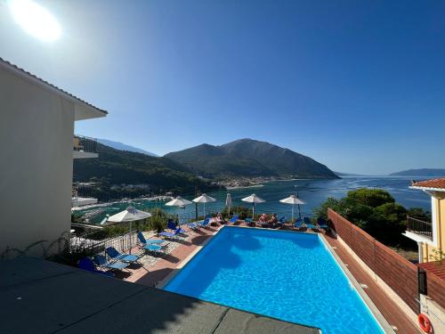 a swimming pool with chairs and a view of the water at Hotel Oceanis in Poros