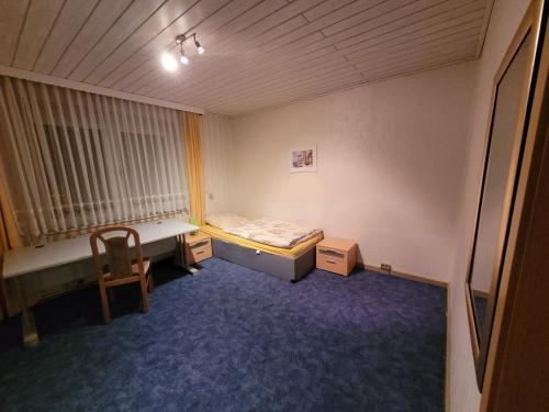 a small room with a bed and a table and a chair at Monteurzimmer Röderland - Langzeitaufenthalte für bis zu 6 Personen in Prösen