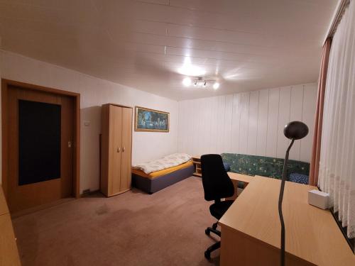 a room with a bed and a desk and a chair at Monteurzimmer Röderland - Langzeitaufenthalte für bis zu 6 Personen in Prösen