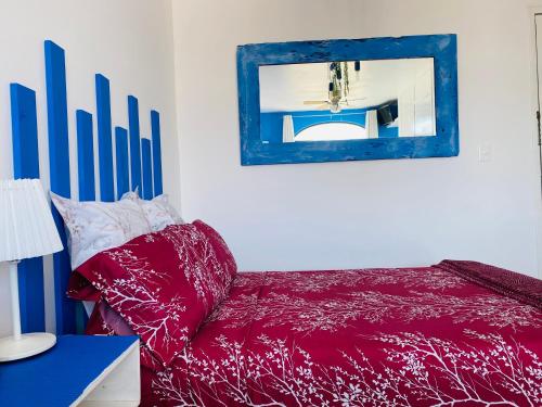a bedroom with a red bed and a mirror at Tropical apartment in Cancún