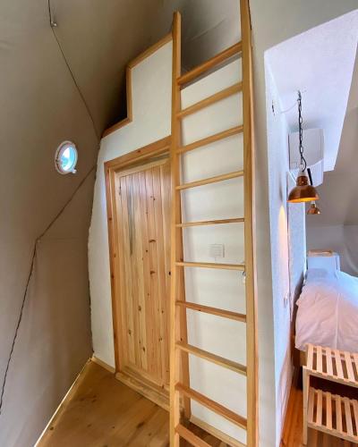 a room with a ladder and a bed in a room at DENGEKORU Wildlife & Glamping in Mudurnu