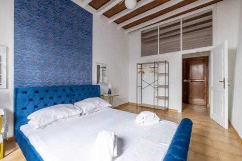 - un grand lit dans une chambre dotée d'un mur bleu dans l'établissement maison pellegrino, à Rome
