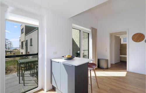 a kitchen with a counter and a view of a balcony at Nice Home In Lembruchdümmer See in Lembruch